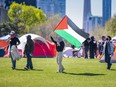 Protester with Palestinian flag with tents in the background