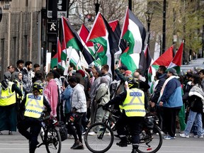 Police watch over the crowd as pro-Palestinian protesters slowly march through the streets of Montreal on May 4, 2024.