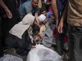 Palestinians mourn relatives killed in the Israeli bombardments of the Gaza Strip in front of the morgue of the Al Aqsa Hospital in Deir al Balah, Gaza Strip, on Saturday, May 11, 2024.