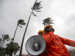 Members of the Bangladesh Red Crescent Society ask people to vacate as strong winds caused by the advancing Cyclone Remal hit the Kuakata beach on the coast of Bay of Bengal in Barisal, Bangladesh, Sunday, May 26, 2024.