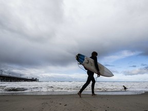 A surfer heads to the water