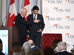 Perrin Beatty, president of the Canadian Chamber of Commerce, points Prime Minister Justin Trudeau to his seat for a fireside discussion, after Trudeau's remarks at the Canadian Chamber of Commerce Hill Day in Ottawa, on Monday, April 15, 2024.