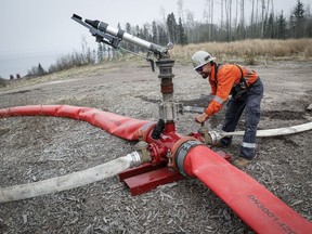 Justin Massie, wildfire specialist with Fire and Flood Emergency Service Ltd., adjusts a valve on a wildfire suppression water cannon along Highway 881 near Gregoire Lake Estates southeast of Fort McMurray, Wednesday, May 15, 2024.