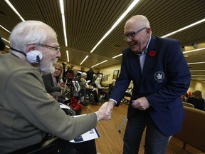 Toronto Maple Leafs Alumni Ron Ellis greets and signs a pennant for veteran Arthur Smoke, 95, at Sunnybrook Hospital as part of Remembrance Day week on Wednesday Nov. 6, 2019.