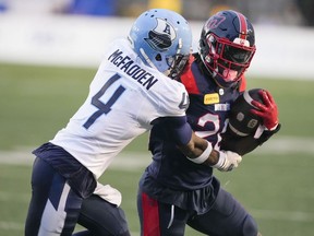 Montreal Alouettes running back Jeshrun Antwi (20) tries to rush past Toronto Argonauts defensive back Tarvarus McFadden (4) during first half pre-season CFL football action in Montreal, Saturday, May 25, 2024.