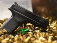 A Springfield Armory Hellcat 9mm micro-sized pistol that has fired 20,000 rounds is displayed with ammunition shell casings during the National Rifle Association (NRA) Annual Meeting at the George R. Brown Convention Center, in Houston, Texas on May 28, 2022.