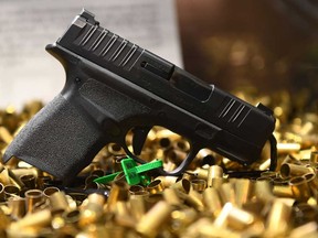 A Springfield Armory Hellcat 9mm micro-sized pistol that has fired 20,000 rounds is displayed with ammunition shell casings during the National Rifle Association (NRA) Annual Meeting at the George R. Brown Convention Center, in Houston, Texas on May 28, 2022.
