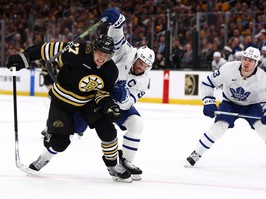 Hampus Lindholm of the Boston Bruins and John Tavares of the Maple Leafs battle for control of the puck during the second period of Game 5 at TD Garden on April 30, 2024 in Boston.