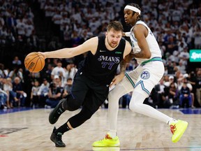 Luka Doncic of the Dallas Mavericks drives to the basket against Jaden McDaniels of the Minnesota Timberwolves during the fourth quarter in Game Two of the Western Conference Finals at Target Center on May 24, 2024 in Minneapolis, Minn.