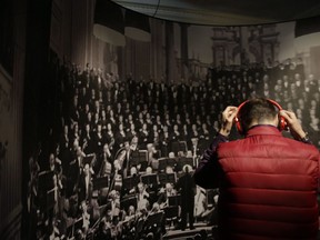 A guest listens Arturo Toscanini's operas on a headphone during the unveiling of the exhibition on the Italian musician and composer, at La Scala opera theatre in Milan, Italy, Tuesday, March 21, 2017.