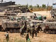 Israeli soldiers approach infantry-fighting vehicles