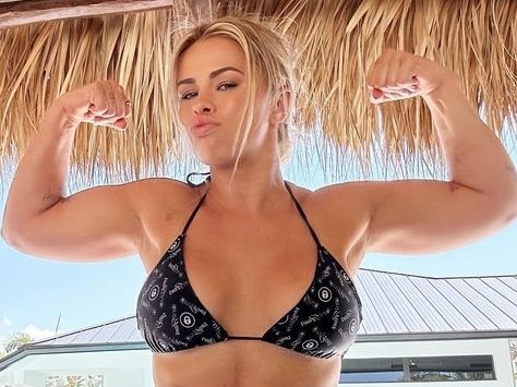 Paige VanZant flexing muscles in bikini.