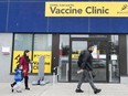 People walk past a vaccine clinic
