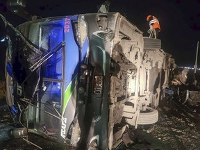 In this handout photo provided by the Peru's Highway Police, rescue workers attend to a bus that collided with a cargo train in La Oroya, Peru, Sunday, May 26, 2024.