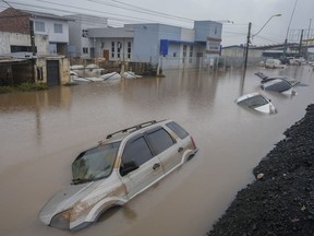 Vehicles are partially submerged on a street flooded by heavy rains in Sao Leopoldo, Rio Grande do Sul state, Brazil, Saturday, May 11, 2024.