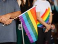 A person holds a pride flag during the Capital Pride Festival flag-raising ceremony at Ottawa City Hall on Aug. 22, 2022.