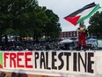 A demonstrator waves a Palestinian flag in front of a few hundred students protesting the Israel-Gaza war Tuesday, at Johns Hopkins University's Homewood Campus in Baltimore.