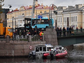 Rescue workers lift the wreckage of a bus