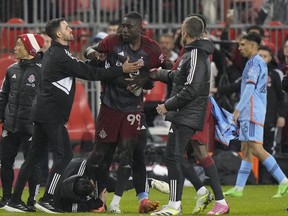 Toronto FC forward Prince Owusu (99) is restrained by team staff members after MLS action against New York City FC in Toronto, Saturday, May 11, 2024. Toronto FC will be missing its coach and five players through suspension for Wednesday's game at Nashville SC after the MLS Disciplinary Committee handed down its initial verdict on Saturday night's ugly post-game melee with New York City FC.