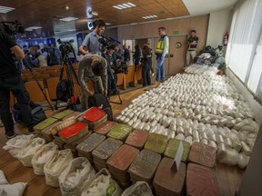 Police officers and journalists stand by part of a haul of 1.8 tons of methamphetamine in Madrid, Spain, Friday, May 16, 2024.
