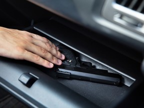 A man taking a handgun from the glovebox