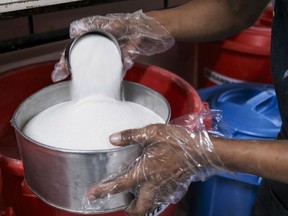 A baker measures refined sugar at a cafe's kitchen in Negros Occidental, the Philippines, on Tuesday, April 30, 2024.