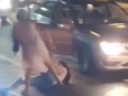 Screenshot of two women fighting on street, one woman is on the ground.
