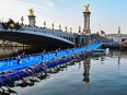 Triathlon athletes start to compete swimming in the Seine river next to the Alexandre III bridge during a Test Event for the women's triathlon for the upcoming 2024 Olympic Games.
