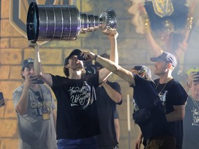 Chandler Stephenson of the Vegas Golden Knights gives Mark Stone a drink as he hoists the Stanley Cup.