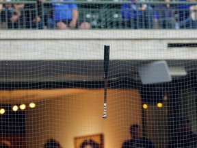 The bat of Toronto Blue Jays' Vladimir Guerrero Jr. hangs stuck in the net above the dugout after his swing in the fourth inning against the Milwaukee Brewers.