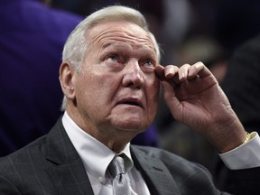 Jerry West wipes his eye while sitting courtside before an NBA basketball game between the Los Angeles Clippers and the Sacramento Kings.