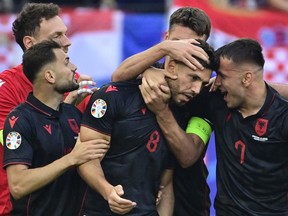 Albania's midfielder Klaus Gjasula celebrates with his teammates after scoring the equalizing goal against Croatia.