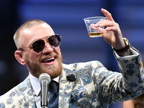 Conor McGregor holds a drink of his Proper Twelve whiskey.