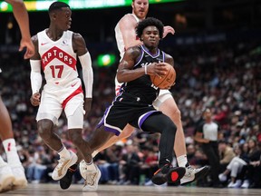 Sacramento Kings' Davion Mitchell drives to the hoop past Toronto Raptors' Dennis Schroder and Jakob Poeltl during a pre-season game last year.