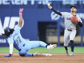 Guardians second baseman Andres Gimenez turns a double play over Vladimir Guerrero Jr. of the Blue Jays during the fourth inning in their MLB game at the Rogers Centre in Toronto, Friday, June 14, 2024.