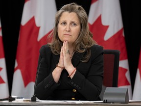 Chrystia Freeland at table with hand pressed together under chin