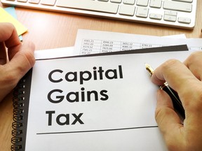 Hands holding documents with title capital gains tax CGT.