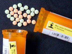 Hydromorphone pills spilling from two containers