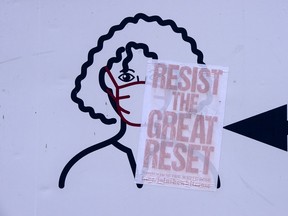 A sticker placed on Covid-19 signage says to “resist the great reset.”