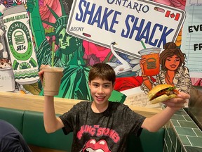 Toronto Sun columnist Joe Warmington's 11-year-old son, JJ, gives a big thumbs up to the new Shake Shack that opened at the corner of Yonge and Dundas Sts. on Thursday, June 13, 2024.