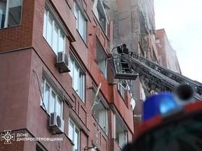 seorang penyelamat dari Layanan Darurat Negara Ukraina bekerja di sebuah gedung apartemen