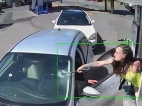 Screenshot of barista at drive-thru taking hammer to customer's windshield.