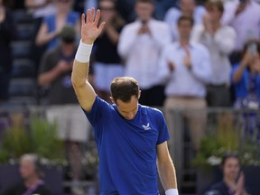Andy Murray of Britain waves to applause from the crowd as he retires due to injury from his match against Jordan Thompson of Australia during their men's singles match on day five of The Queen's Club tennis tournament, in London, Wednesday, June 19, 2024.