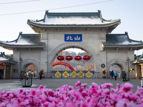 Tourists walk past a gateway with the name "Beishan" seen at the Beishan Park in northeastern China's Jilin province on Jan 23, 2020.