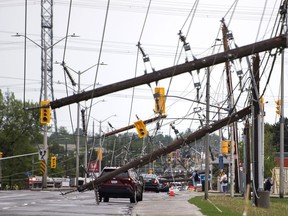 A vehicle is seen among downed power lines and utility poles after a major storm on Merivale Road in Ottawa on Saturday, May 21, 2022. The Local Leadership for Climate Adaptation initiative will offer up to $1 million to local governments for projects that upgrade or adjust their infrastructure and natural environment to be more protected from extreme weather events including floods, fires and major storms.