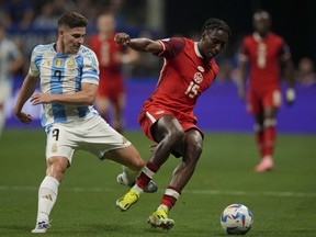 Argentina's Julian Alvarez, left, and Canada's Moise Bombito battle for the ball during a Copa America Group A soccer match in Atlanta, Thursday, June 20, 2024.