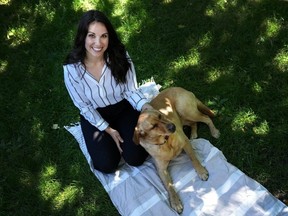 Victims service employee Megan Ireland and Labrador Retriever Penny pose for a photograph in Toronto on Friday, June 14, 2024.