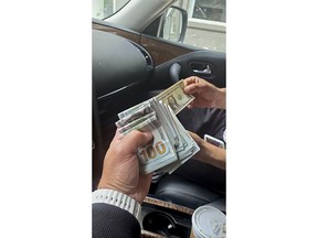 In this June 2023 photo taken by an undercover agent and provided by the U.S. Attorney's office, an undercover agent posing as a hitman, left, holds money received as a partial advance payment for murder during a transaction in New York. U.S. officials became aware in the spring of a plot to kill Gurpatwant Singh Pannun, an American-Canadian citizen who advocates for the creation of a sovereign Sikh state.