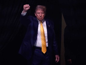 Former U.S. president and 2024 Republican presidential candidate Donald Trump raises his fist as he walks off stage after participating in a town hall event at Dream City Church in Phoenix, Ariz., on June 6, 2024.