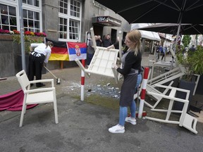 People cleaning up the trash after fans clashes ahead the Group C match between Serbia and England at the Euro 2024 soccer tournament in Gelsenkirchen, Germany, Sunday, June 16, 2024.